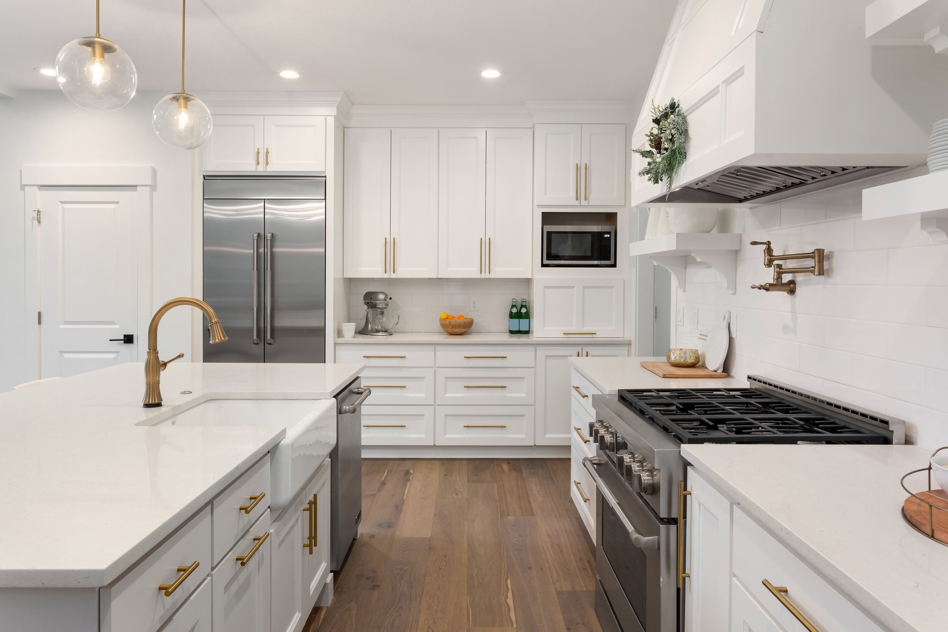 beautiful kitchen in new luxury home with island, pendant lights, and hardwood floors