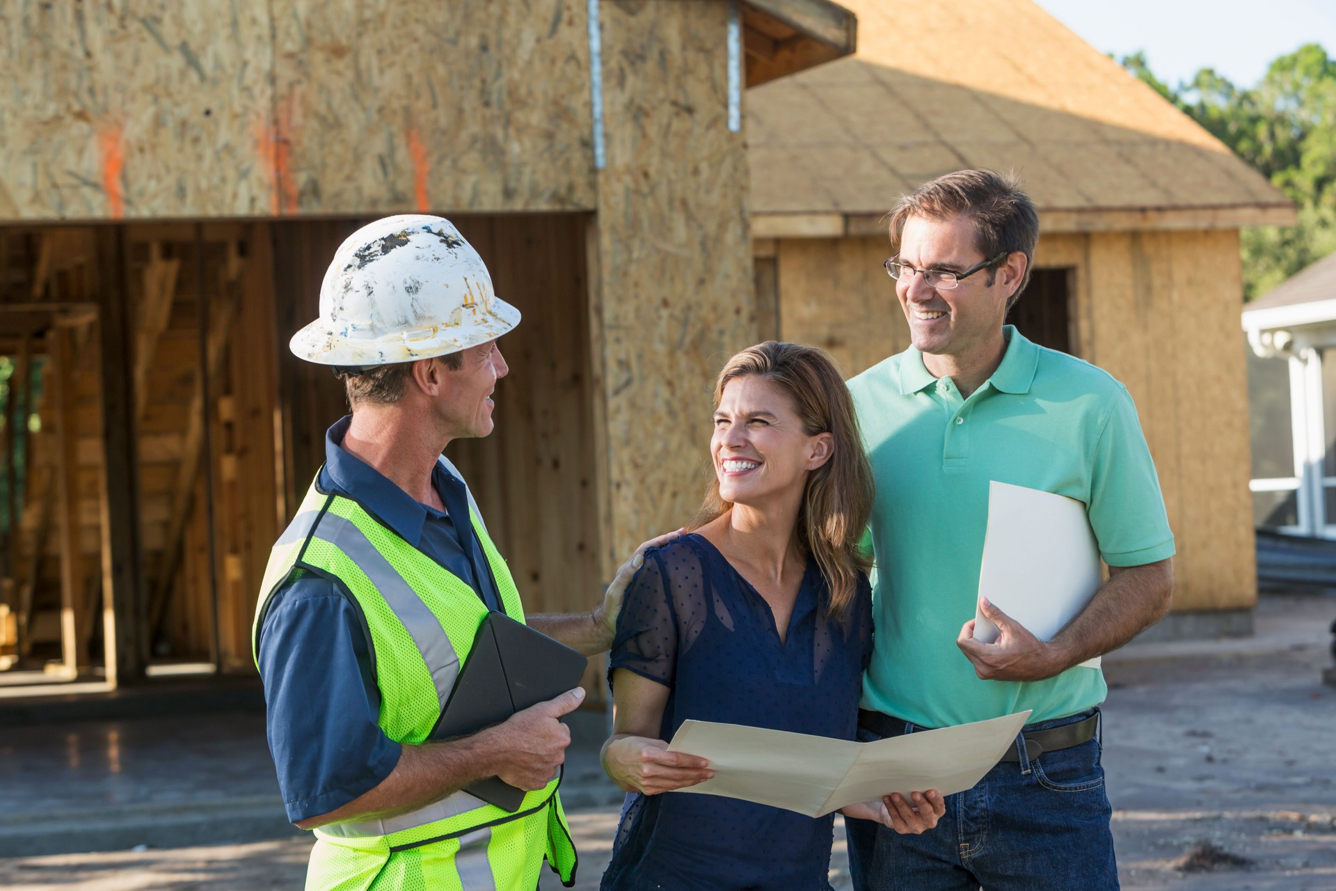 Builder and couple at new home under construction