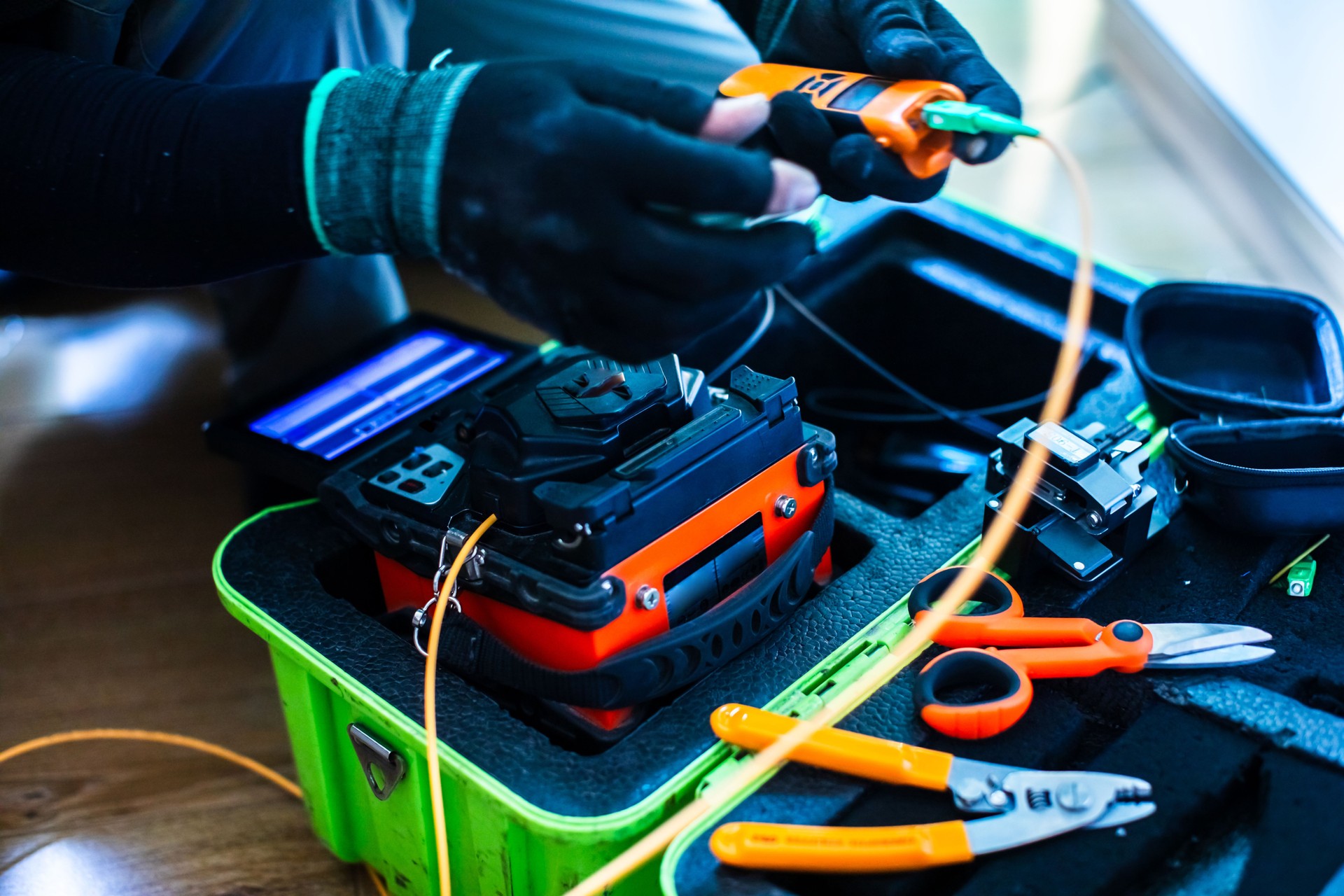 Selective focus to fiber optic splicing cable tools. Fixing Internet Cable. Technician is welding fiber optic cable at the job site.