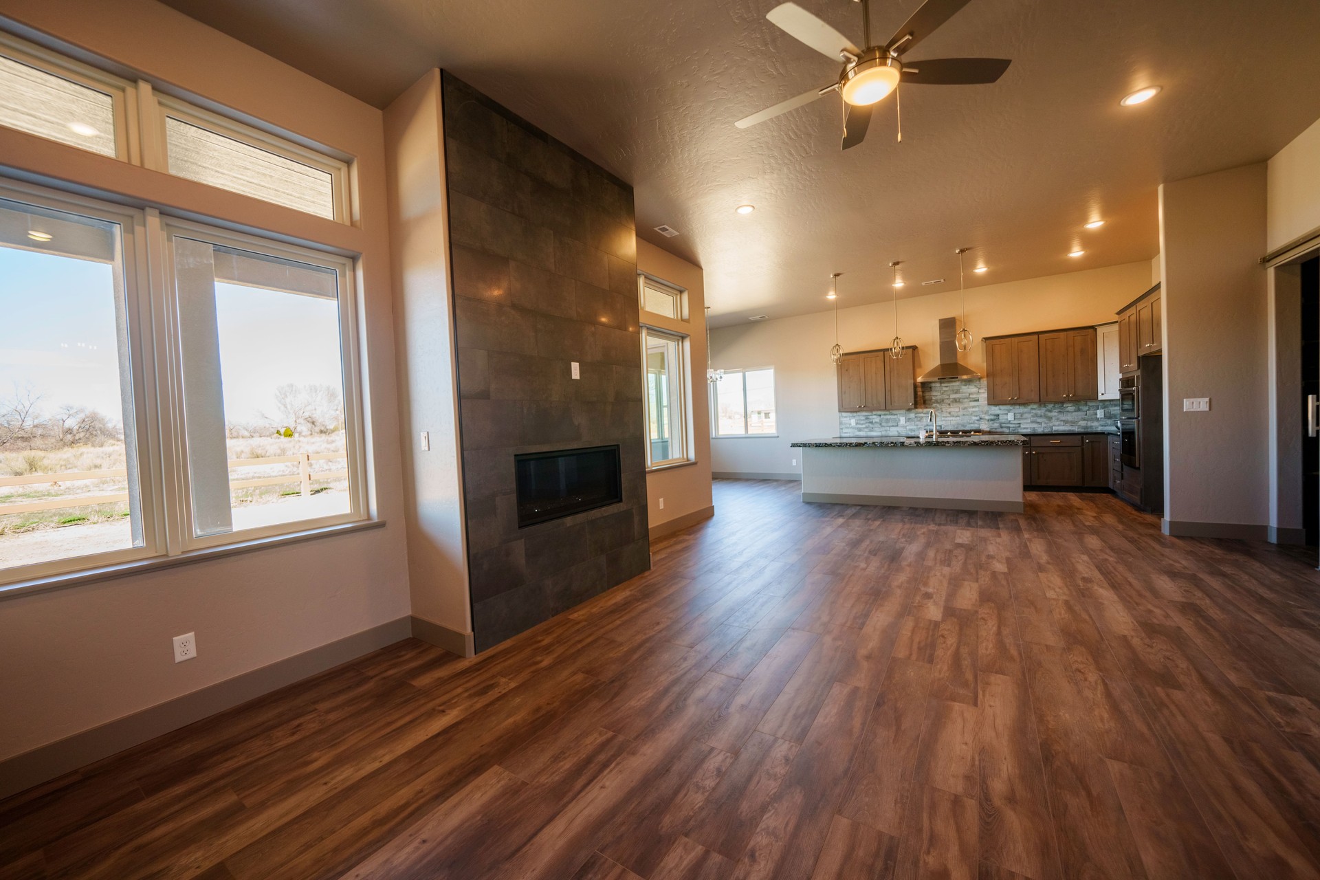 Wide Angle View of a Modern Executive Home Interior with Open Concept, Hardwood Floors, Designer Lighting and Granite Kitchen Counter Top